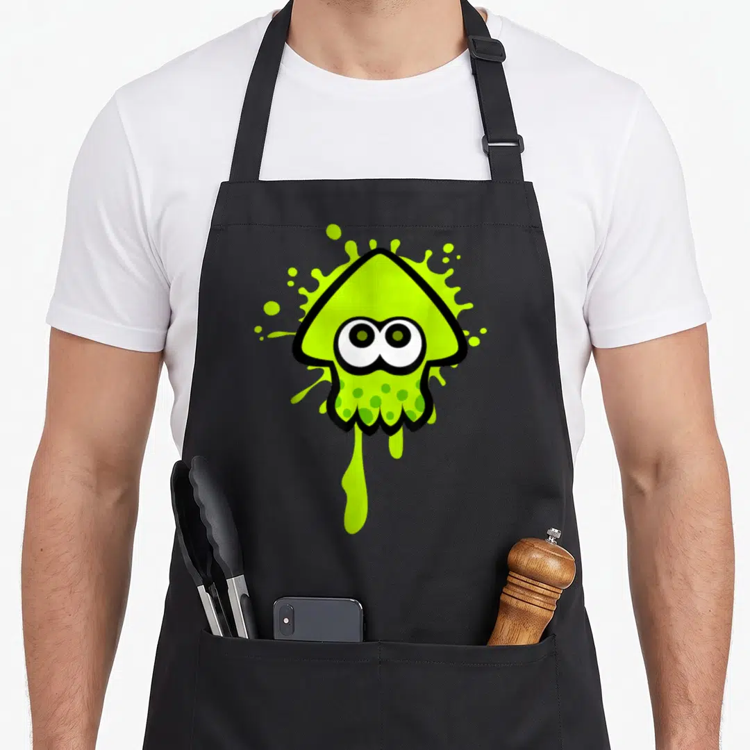 Splat squid apron - Lime green cartoon squid with black outline over paint splatter background — shown on a black cotton canvas apron against a white background