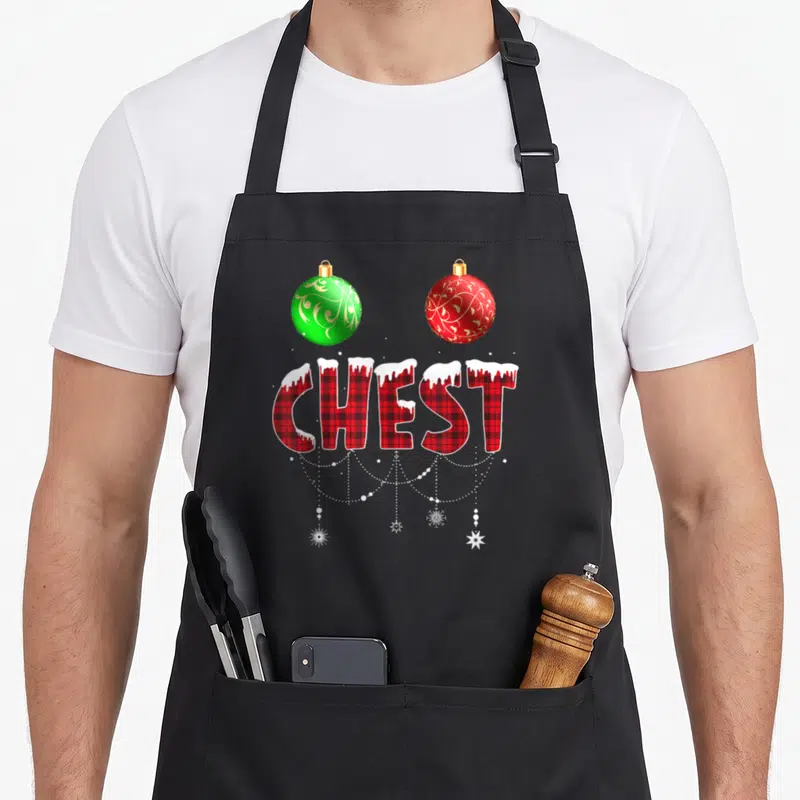 Chest couples christmas aprons - CHEST in red plaid with snow, two ornaments, and hanging string lights — shown on a black cotton canvas apron against a white background