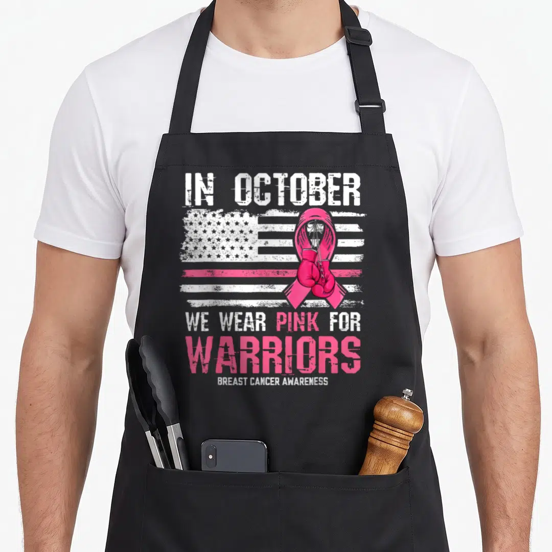 October warrior breast cancer awareness aprons - Distressed USA flag with pink ribbon and boxing gloves, text reading — shown on a black cotton canvas apron against a white background