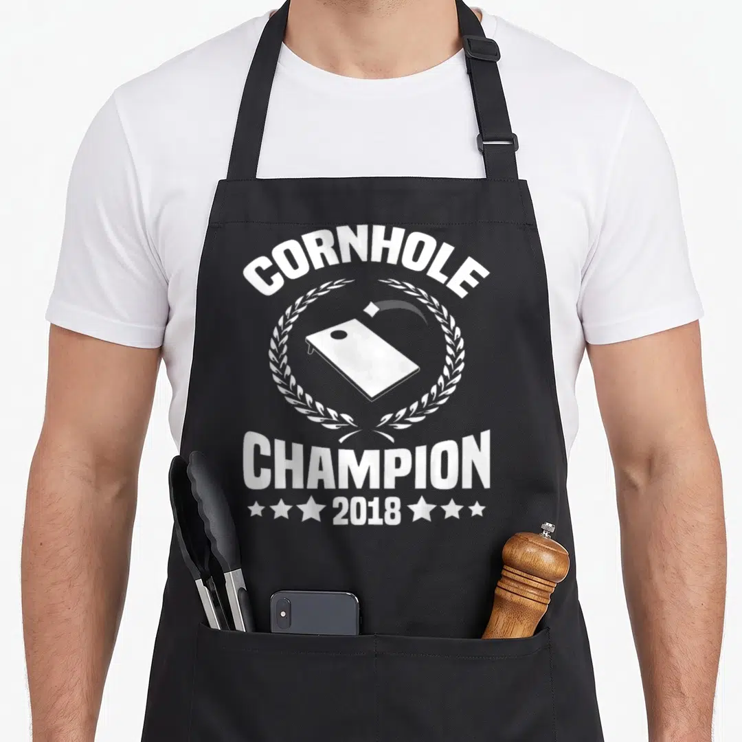 Champion bags and aprons - White cornhole board laurel wreath champion 2018 text apron design — shown on a black cotton canvas apron against a white background