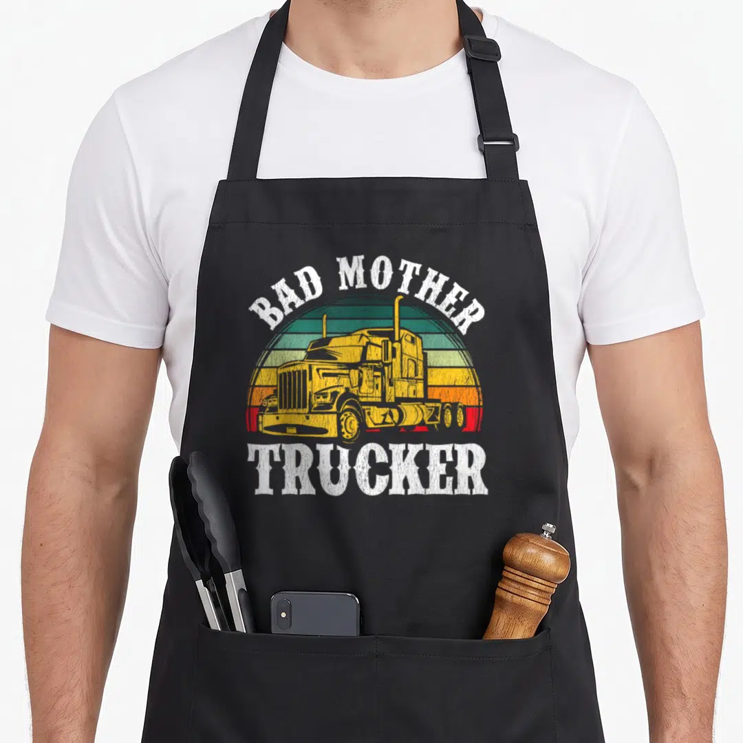 Trucker rig driver truck apron - Yellow semi-truck on striped sun with Bad Mother Trucker text — shown on a black cotton canvas apron against a white background