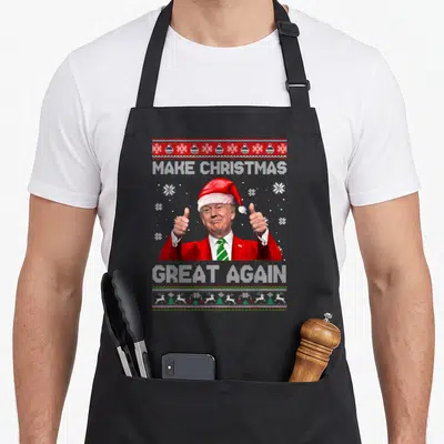 Christmas xmas apron - Trump cartoon thumbs up with Make Christmas Great Again text and snowflakes — shown on a black cotton canvas apron against a white background