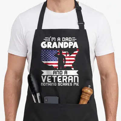 Grandpa patriotic apron - Soldier silhouette saluting US flag map with stacked text I'm a Dad Grandpa and a Veteran — shown on a black cotton canvas apron against a white background