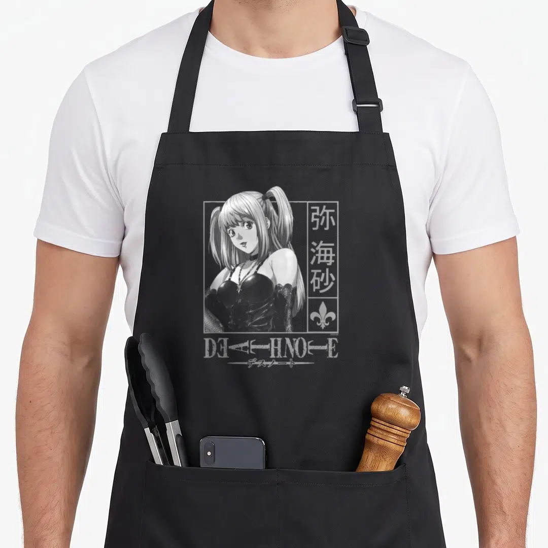 Misa anime apron - Woman in rectangular frame with kanji, fleur-de-lis, and DEATH NOTE text in white and grey — shown on a black cotton canvas apron against a white background