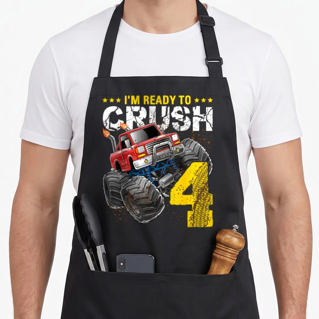 Crush monster truck apron - Red monster truck with yellow number 4 and cracked text reading I'm Ready to Crush — shown on a black cotton canvas apron against a white background