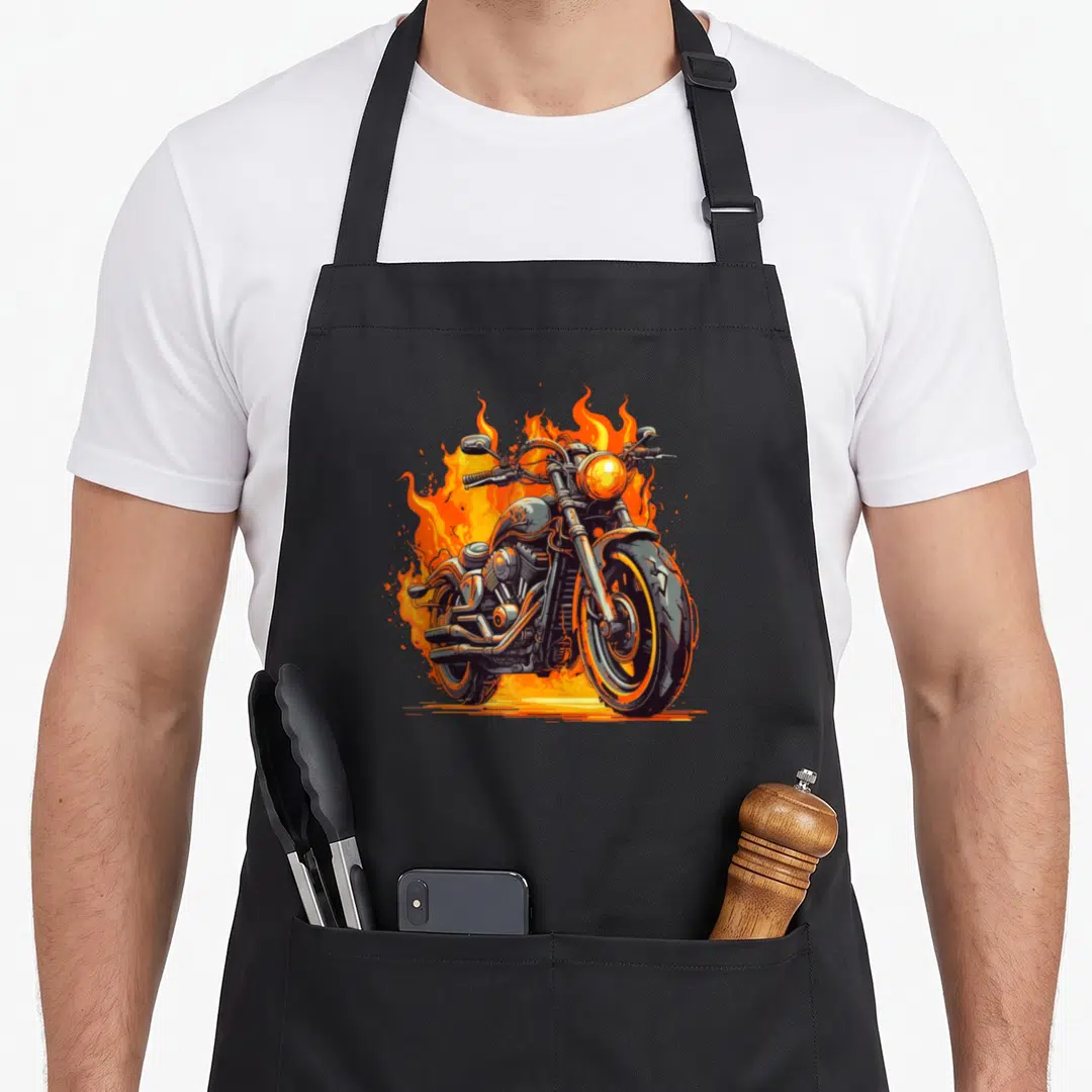 Flame motorcycle apron - Cartoon motorcycle centered in orange and yellow flames on black details — shown on a black cotton canvas apron against a white background
