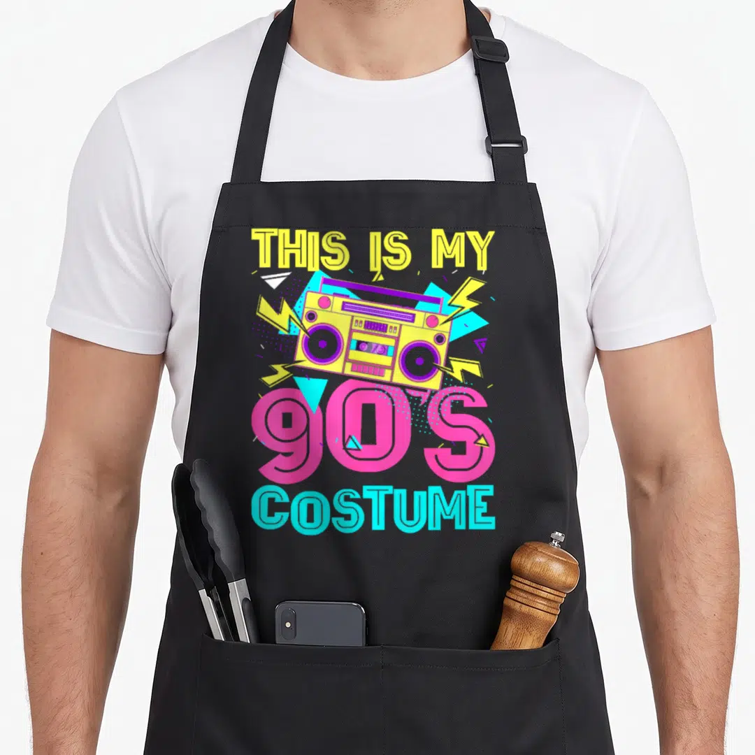 90s theme aprons - Yellow boombox with lightning bolts and text This Is My 90s Costume — shown on a black cotton canvas apron against a white background
