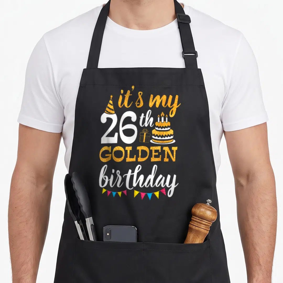 26th golden apron - Gold and white text it's my 26th GOLDEN birthday with cake gift and bunting flags — shown on a black cotton canvas apron against a white background