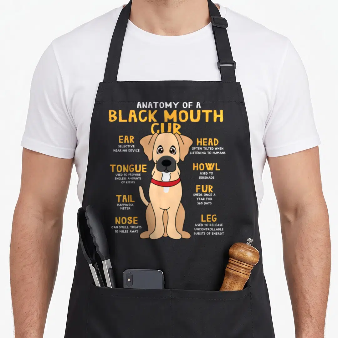 Mouth dog apron - Tan cartoon Black Mouth Cur with labeled anatomy parts and yellow text definitions — shown on a black cotton canvas apron against a white background