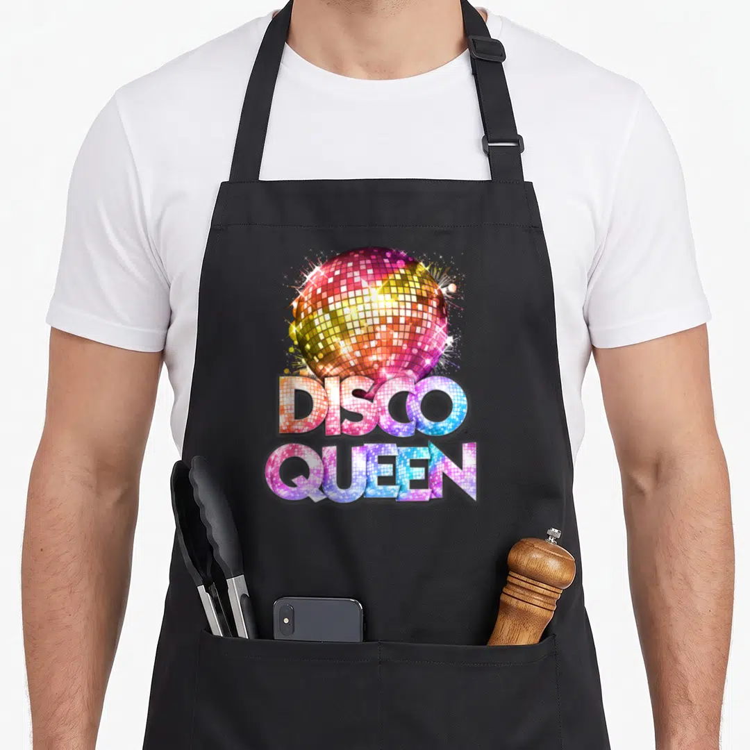 Themed 70s apron - Disco ball and text filled with pink blue yellow purple mirrored tile pattern — shown on a black cotton canvas apron against a white background