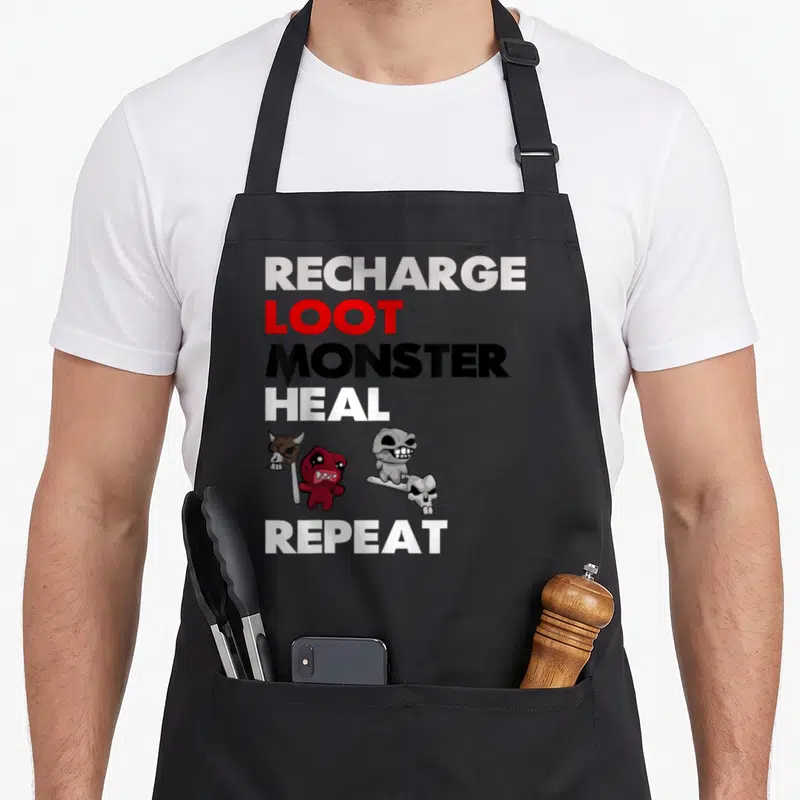 Binding game aprons - Vertical text RECHARGE LOOT MONSTER HEAL REPEAT with red monster and skull staff in cartoon style — shown on a black cotton canvas apron against a white background