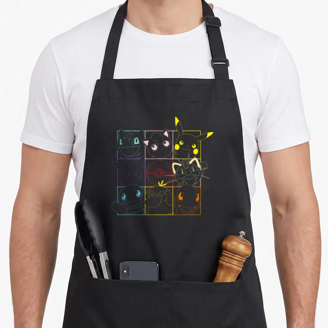 Grid trend apron - Nine Pokemon line-art drawings in colored square frames with central Pokeball — shown on a black cotton canvas apron against a white background