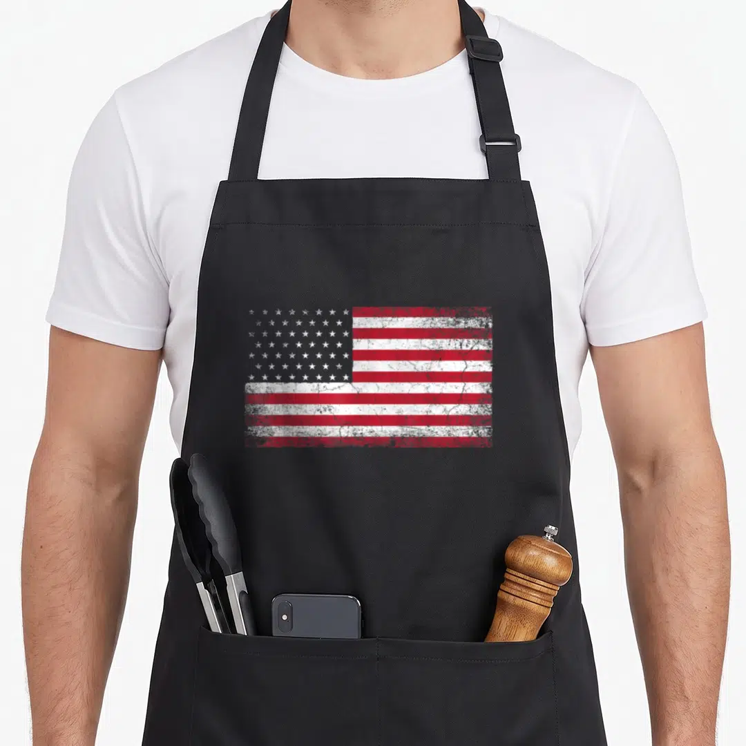 Country 4th of july apron - Distressed red white and blue rectangular flag print on canvas apron — shown on a black cotton canvas apron against a white background