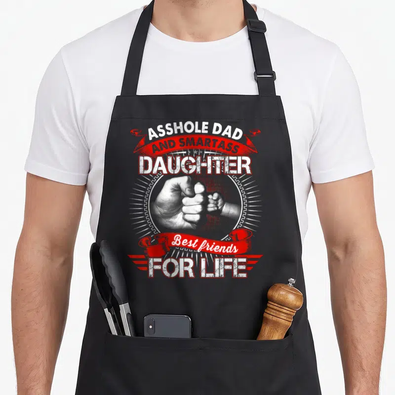 Smartass mom daughter aprons - Fist bump photo with Asshole Dad and Smartass Daughter text in white and red — shown on a black cotton canvas apron against a white background