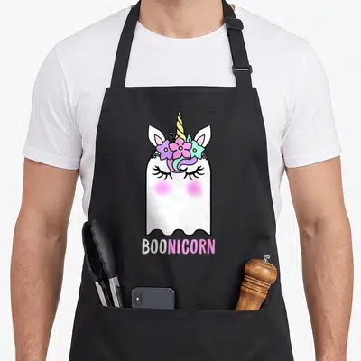 Boonicorn halloween apron - Cartoon ghost with unicorn horn and flower crown above text BOONICORN in white and pink — shown on a black cotton canvas apron against a white background