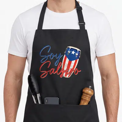 Puerto salsa apron - Soy Salsero text overlapping a conga drum with Puerto Rican flag colors in distressed style — shown on a black cotton canvas apron against a white background