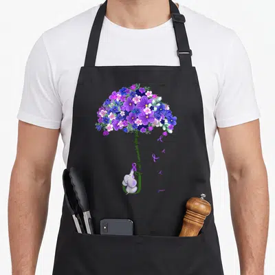 Ill elephant print apron - Purple and blue flower canopy with elephant holding green ribbon and curved text — shown on a black cotton canvas apron against a white background