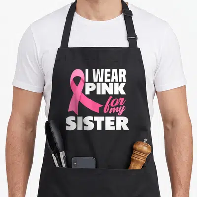 Funny sister breast cancer awareness aprons - Pink ribbon overlapping white and pink text reading I WEAR PINK for my — shown on a black cotton canvas apron against a white background