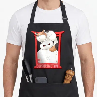 Baymax cat apron - Baymax in red torii gate with calico cat on head and SUPPORTIVE TYPE text — shown on a black cotton canvas apron against a white background