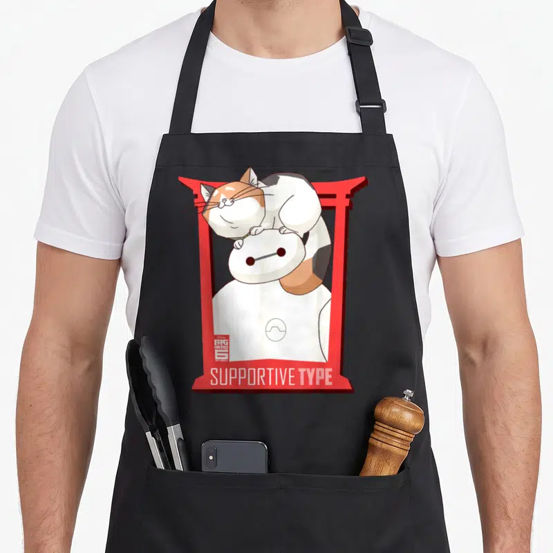 Baymax cat apron - Baymax in red torii gate with calico cat on head and SUPPORTIVE TYPE text — shown on a black cotton canvas apron against a white background