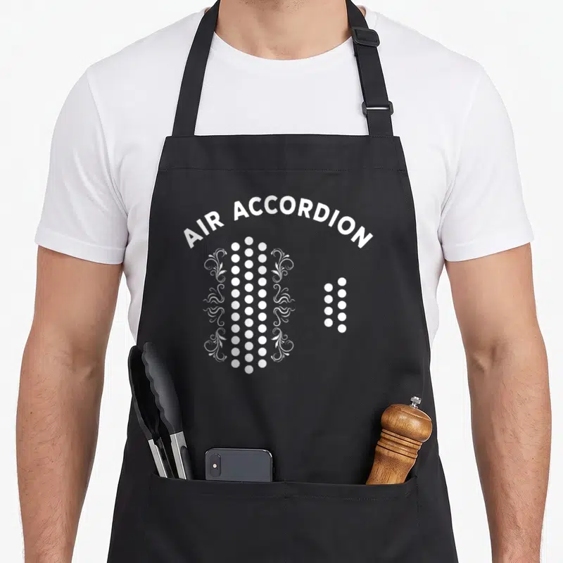 Musical accordion apron - Arched AIR ACCORDION text above white dots and floral swirls — shown on a black cotton canvas apron against a white background