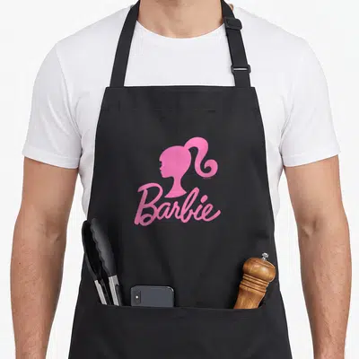 Drink novelty apron - Pink Barbie silhouette and script logo on pink background — shown on a black cotton canvas apron against a white background