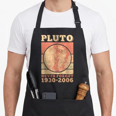 Pluto forget science apron - Retro poster style Pluto planet graphic with NEVER FORGET 1930-2006 text on beige and red — shown on a black cotton canvas apron against a white background