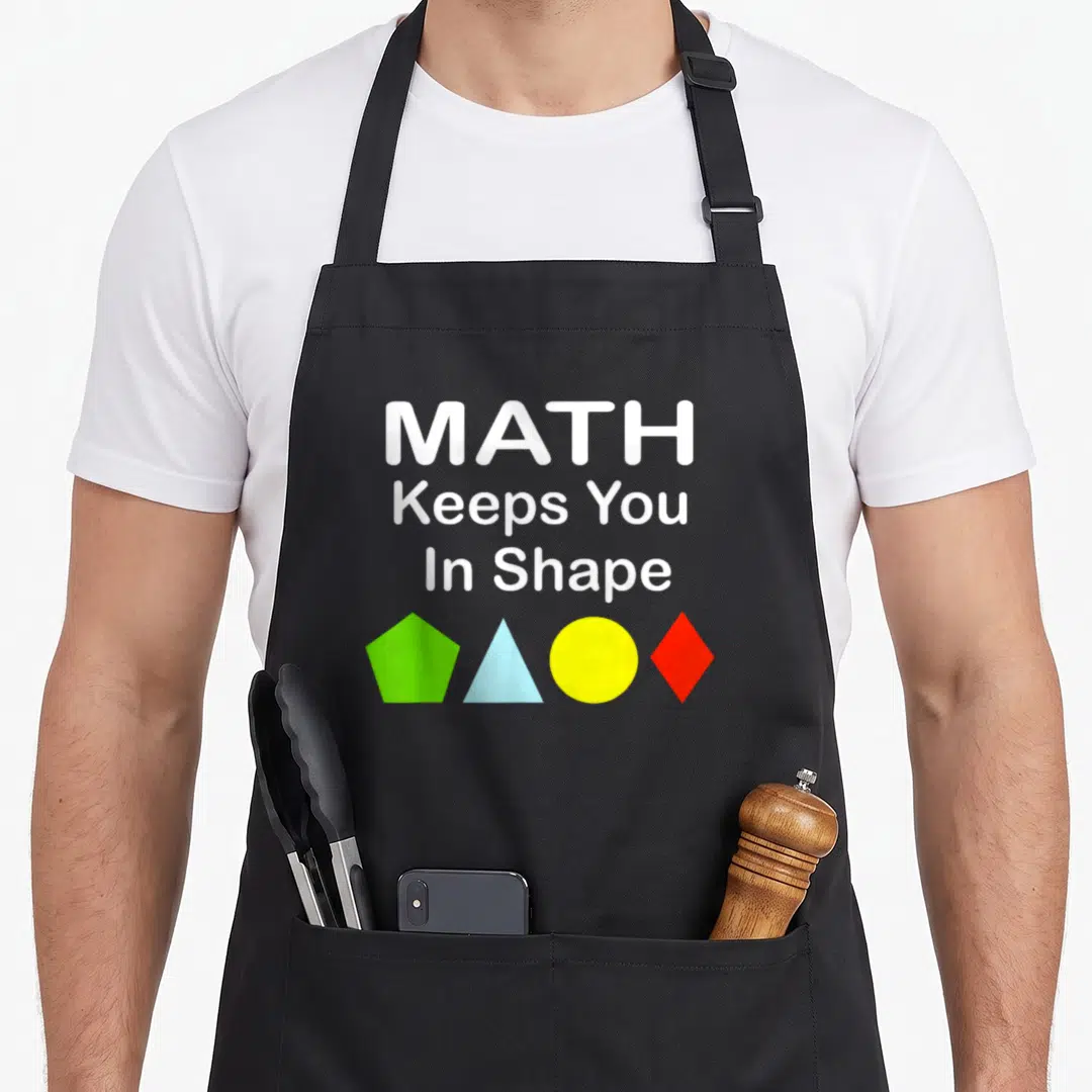 Workout teacher apron - MATH Keeps You In Shape text above green pentagon blue triangle yellow circle and red diamond — shown on a black cotton canvas apron against a white background