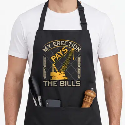 Crane construction apron - Yellow crane over grey grid with MY ERECTION PAYS THE BILLS text in distressed style — shown on a black cotton canvas apron against a white background