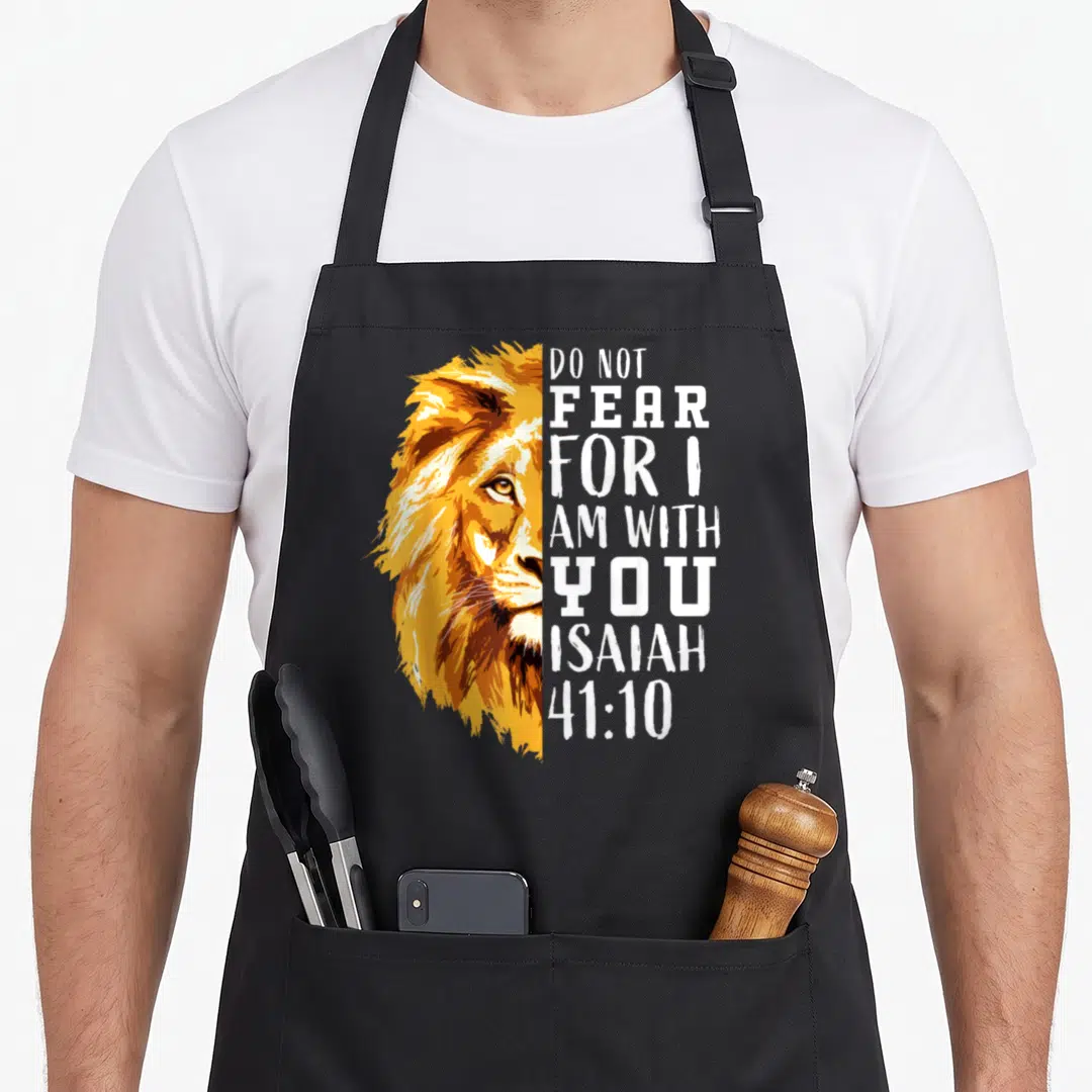 Christian religious bible verse apron - Realistic lion face half next to Do Not Fear For I Am With You Isaiah 41:10 text — shown on a black cotton canvas apron against a white background