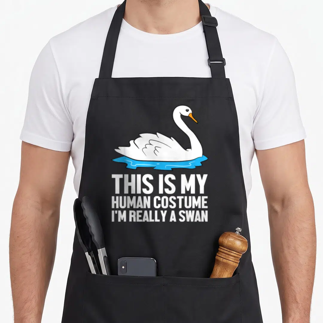 Costume i love my swan apron - Cartoon white swan on blue water above stacked white text reading human costume joke — shown on a black cotton canvas apron against a white background