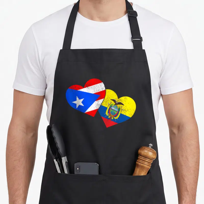 Puerto ecuador apron - Two overlapping hearts containing Puerto Rican and Ecuadorian flags in red, white, blue — shown on a black cotton canvas apron against a white background
