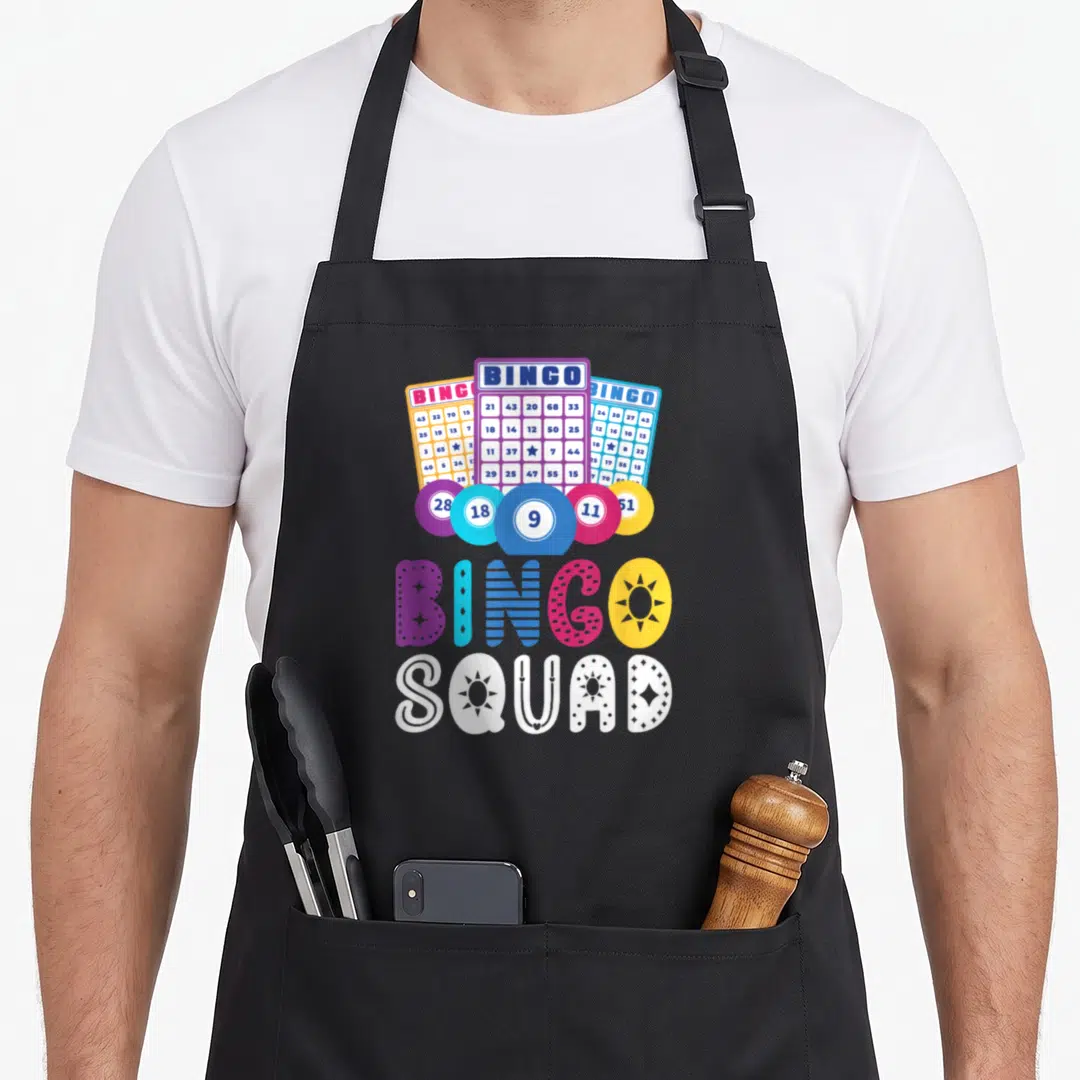 Humour bingo aprons - Three bingo cards and five chips above colorful BINGO SQUAD text in cartoon style — shown on a black cotton canvas apron against a white background