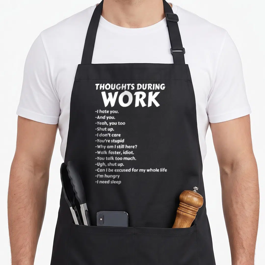 Thought sarcastic apron - White typography listing 15 sarcastic work thoughts like I hate you and I need sleep on black — shown on a black cotton canvas apron against a white background