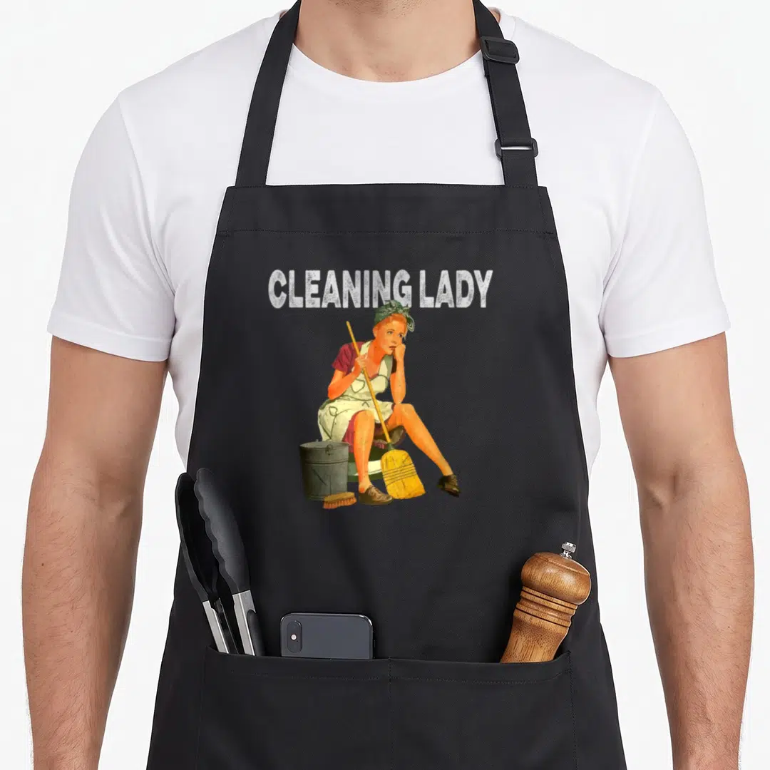 Maid housekeeper apron - Retro illustration of a seated cleaning lady with broom, bucket, and brush under white text — shown on a black cotton canvas apron against a white background