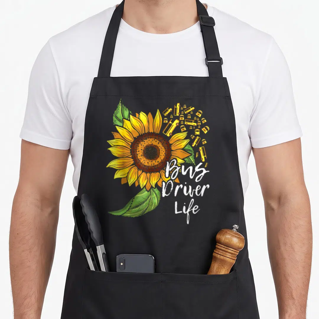 Appreciation bus driver apron - Sunflower and small yellow buses with Bus Driver Life script text — shown on a black cotton canvas apron against a white background