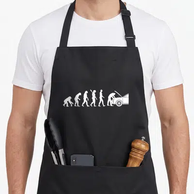 Car engineer mechanic apron - Five white silhouettes showing evolution from ape to man leaning over a car engine — shown on a black cotton canvas apron against a white background