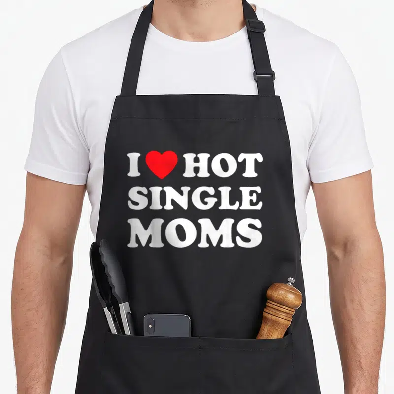 Single love hot apron - Stacked white text I HOT SINGLE MOMS with red heart between I and HOT — shown on a black cotton canvas apron against a white background