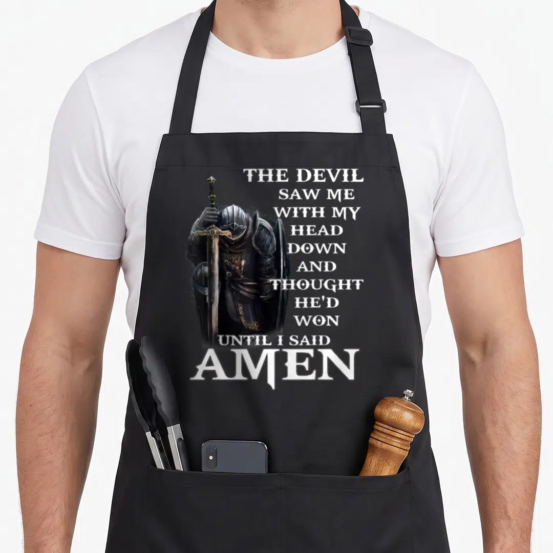 Hed devil's apron - Knight in black armor with sword beside stacked white prayer text ending in silver AMEN — shown on a black cotton canvas apron against a white background