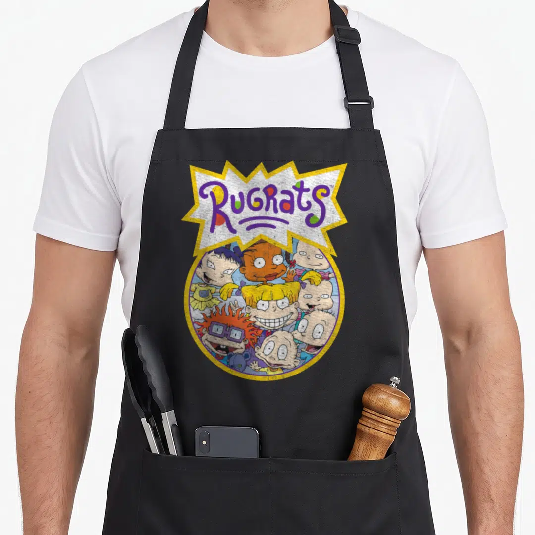 Baby circle time apron - Rugrats logo in jagged burst above circle of cartoon baby faces in yellow purple blue orange — shown on a black cotton canvas apron against a white background