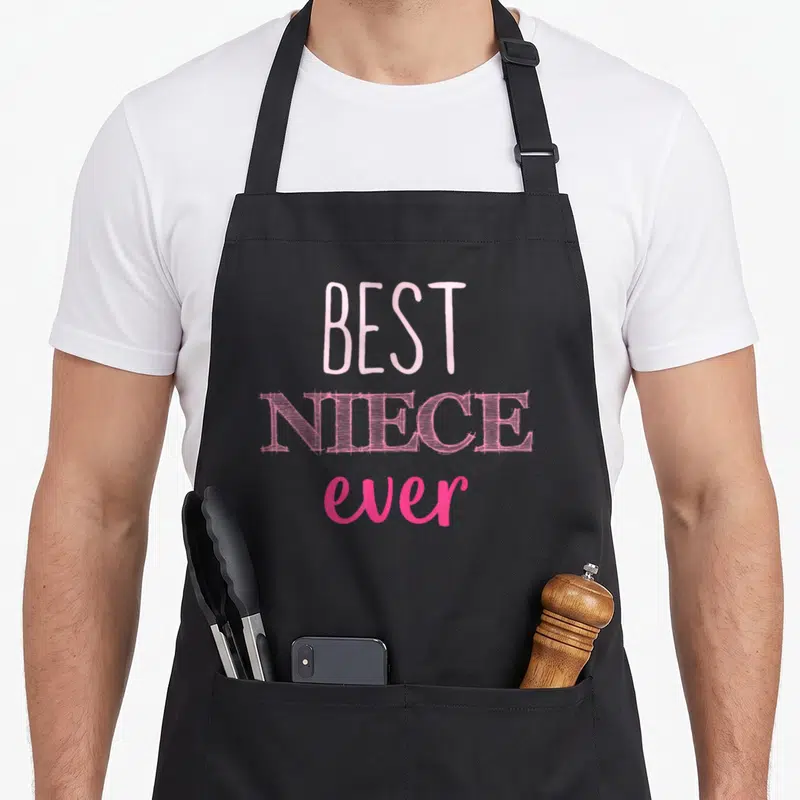 Funny niece apron - Stacked pink text reading BEST NIECE ever in three different font styles — shown on a black cotton canvas apron against a white background