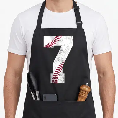 7th baseball apron - Large distressed number 7 filled with white texture and red baseball stitching — shown on a black cotton canvas apron against a white background