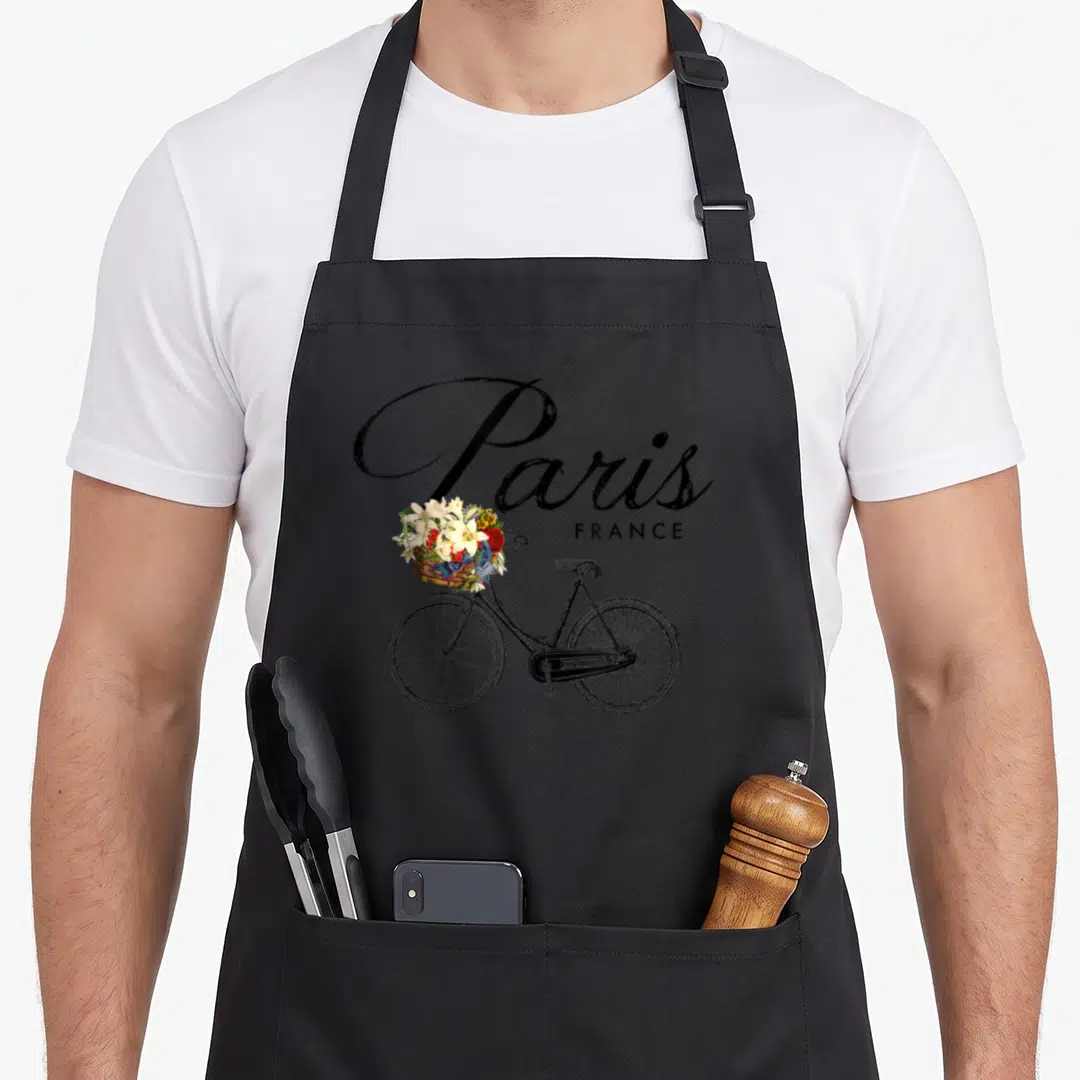 Bike paris apron - Retro bicycle with flower basket and Paris France script lettering — shown on a black cotton canvas apron against a white background