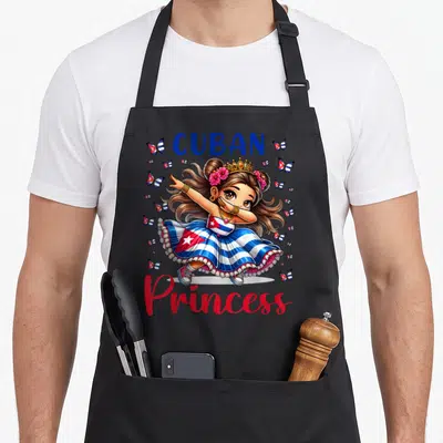 Cuban princess apron - Cartoon girl dabbing in flag dress surrounded by flag butterflies and text — shown on a black cotton canvas apron against a white background