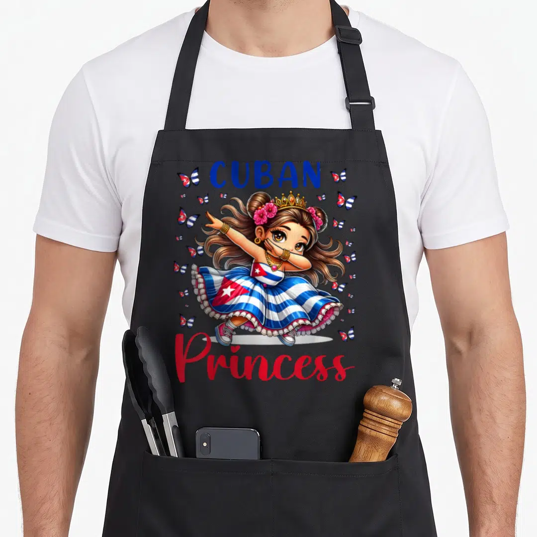 Cuban princess apron - Cartoon girl dabbing in flag dress surrounded by flag butterflies and text — shown on a black cotton canvas apron against a white background