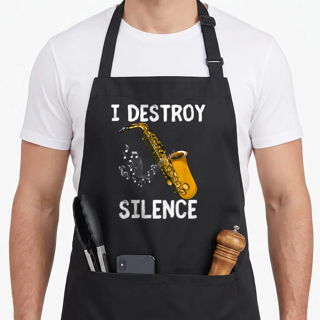 Destroy saxophone apron - Gold cartoon saxophone with white notes and I Destroy Silence text — shown on a black cotton canvas apron against a white background