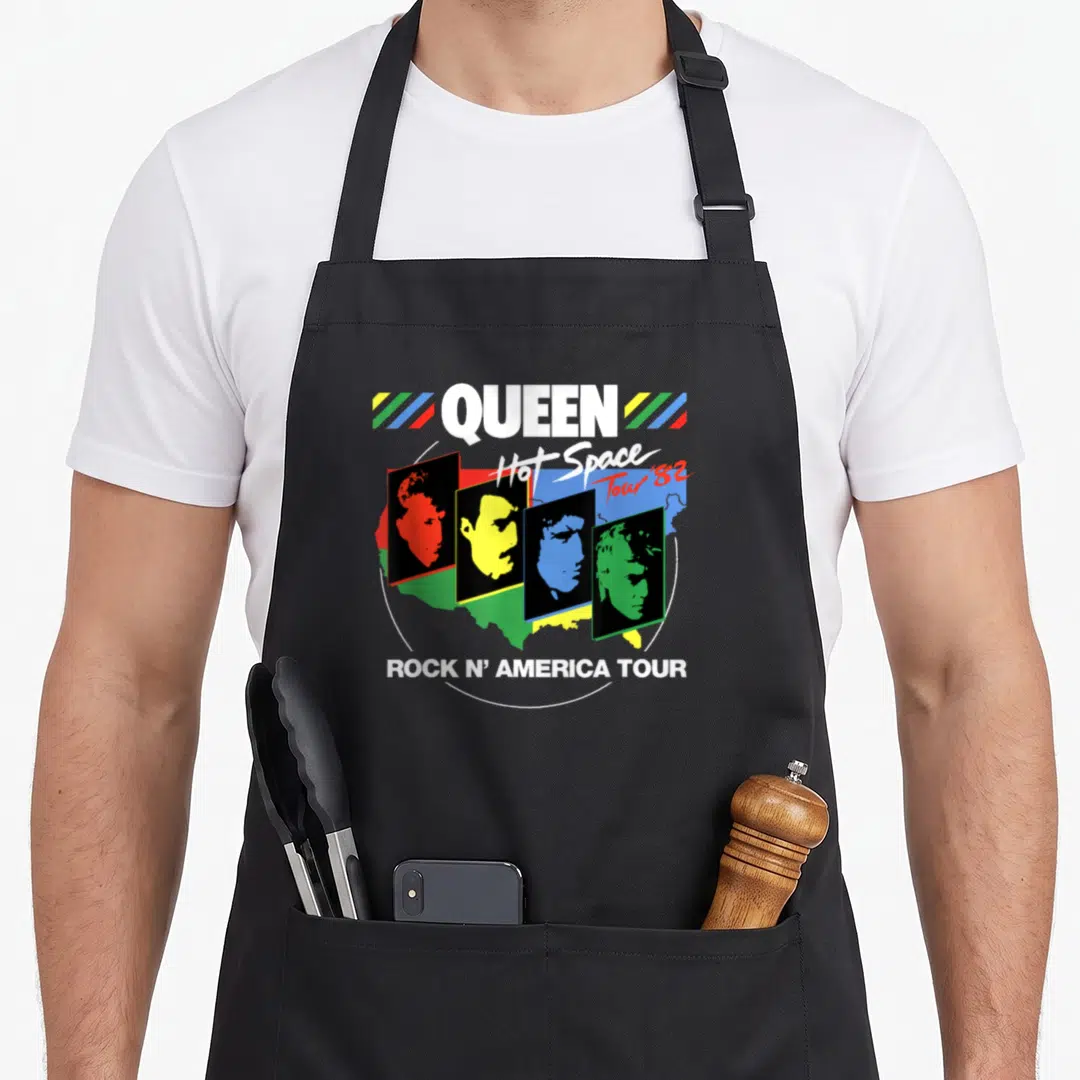 Hot queen apron - QUEEN Hot Space Tour 82 band profiles in colored rectangles over USA map — shown on a black cotton canvas apron against a white background