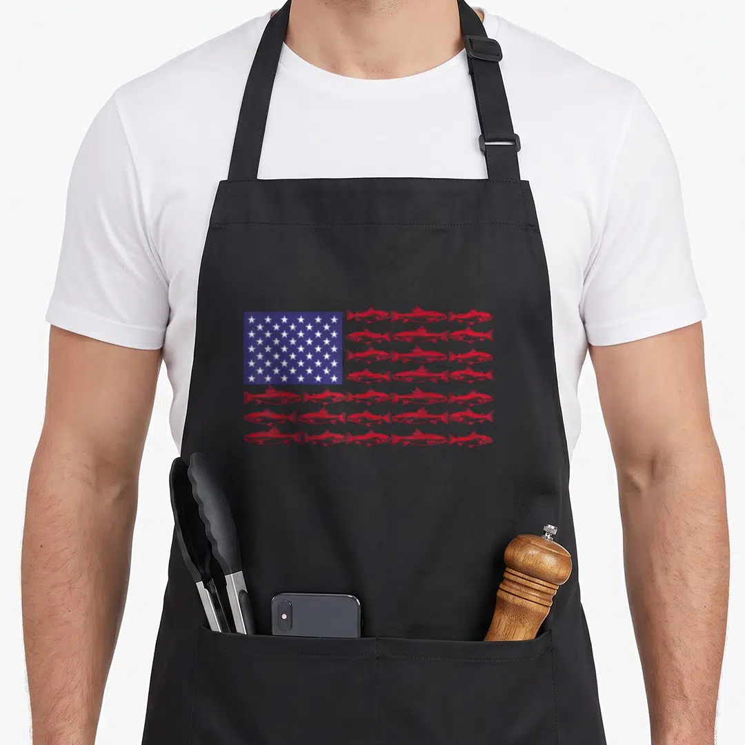 Largemouth american flag apron - Red fish arranged in rows forming stripes next to a blue rectangle with white stars — shown on a black cotton canvas apron against a white background