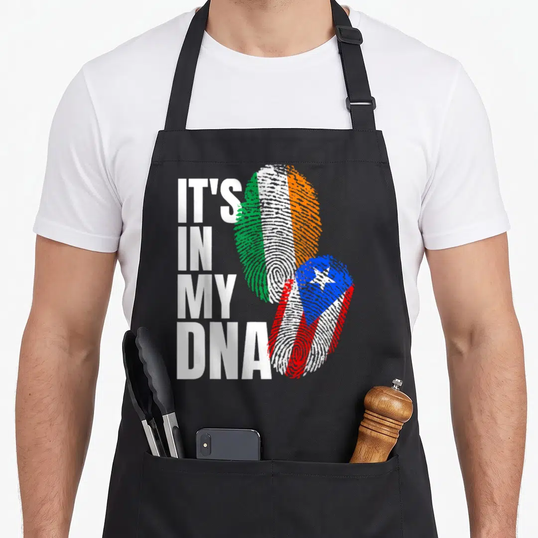 Puerto irish aprons - Stacked IT'S IN MY DNA text next to two fingerprint flags in Irish and Puerto Rican colors — shown on a black cotton canvas apron against a white background