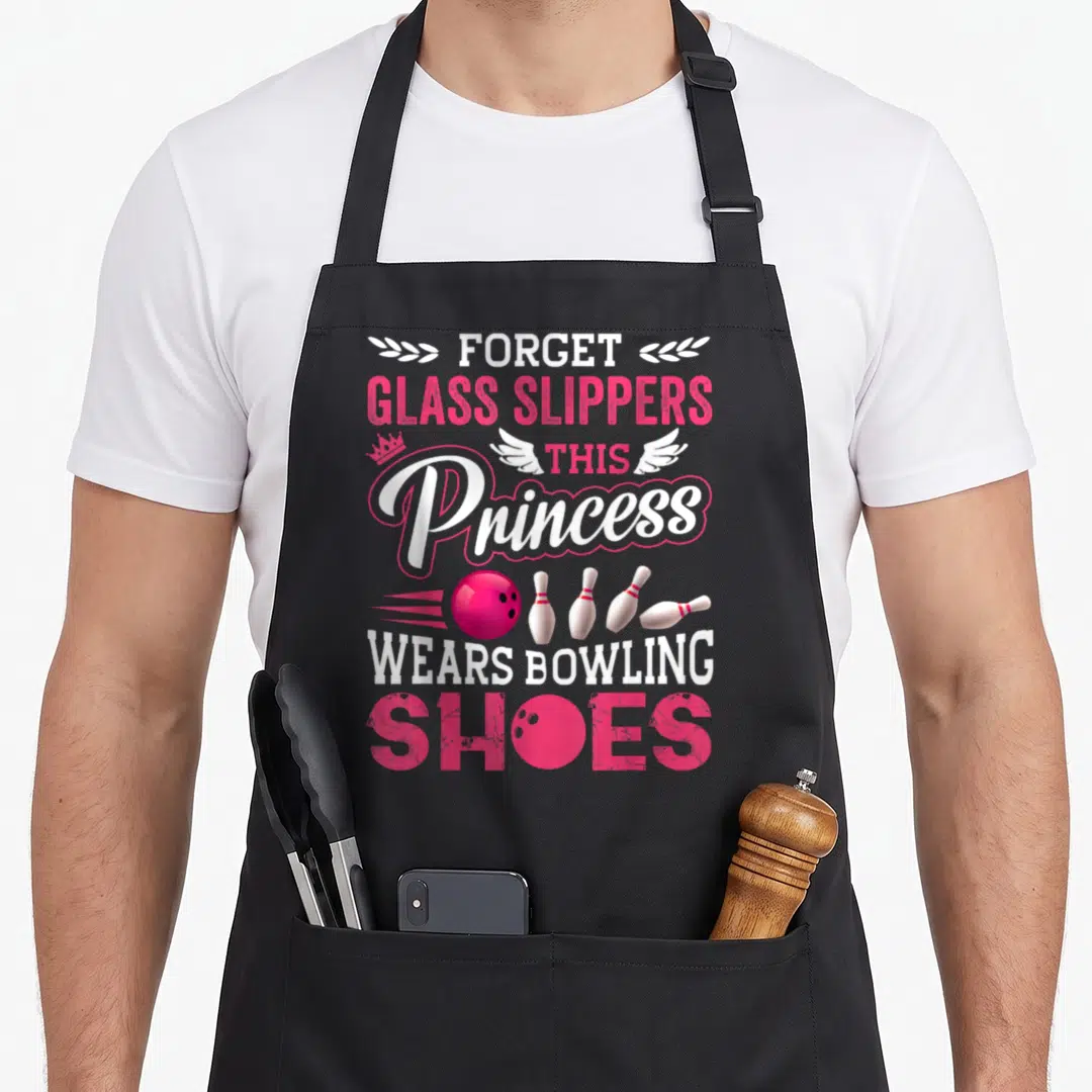 Bowling wife apron - Pink and white text reading forget glass slippers this princess wears bowling shoes with ball — shown on a black cotton canvas apron against a white background